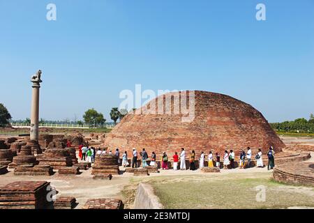 9. März 2020, Kolhua, Vaishali, Bihar, Indien. Ananda Stupa mit einer Asokan-Säule. Eifrige Anhänger umgehen den Stupa. Relikt Stupa, die ein o umschließt Stockfoto