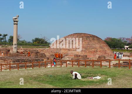 9. März 2020, Kolhua, Vaishali, Bihar, Indien. Ananda Stupa mit einer Asokan-Säule. Eifrige Anhänger umgehen den Stupa. Relikt Stupa, die ein o umschließt Stockfoto