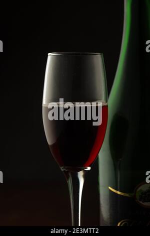 Ein Glas Rotwein mit Rotwein Flasche für Feiern Party während Neujahr Abend Stockfoto