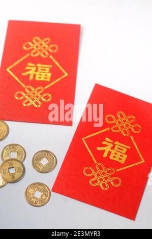 Roter Umschlag namens "Ang Pao" und Goldmünzen in chinesischen Neujahrskonzept, Sparkonzept und Reichtum. Stockfoto