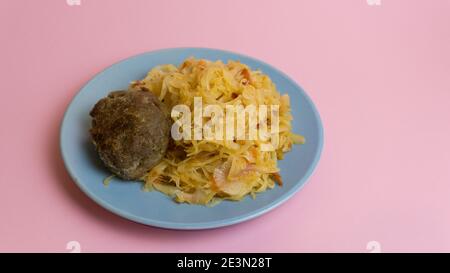 Geschmorter Weißkohl mit einem Cutlet Steak auf einem Teller. Ein Gericht der russischen Küche. In der UdSSR garnieren. Stockfoto