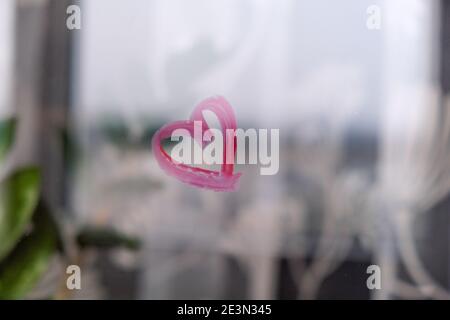 Herz auf Glas mit Lippenstift gemalt. Valentinstag. Liebe und Romantik. Herz gezeichnet von einem Lippenstift. Angezeigt. Lippenstift mit Beschriftung Stockfoto