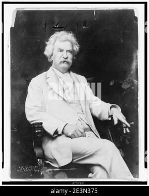 Mark Twain, dreiviertel langes Porträt, sitzend, leicht nach rechts ausgerichtet, mit Zigarre in der Hand Stockfoto