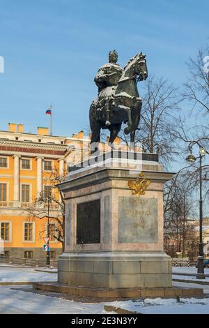 Sankt Petersburg, Russland - 16. Januar 2021: Statue von Peter dem Großen auf einem Sockel vor dem Mikhailowski Schloss mit der russischen Flagge in wint Stockfoto