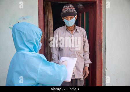 Frauen Krankenschwester Arbeiter in ppe-Kit tun Tür zu Tür Umfragen im indischen Dorf bezüglich Covid-19 Stockfoto