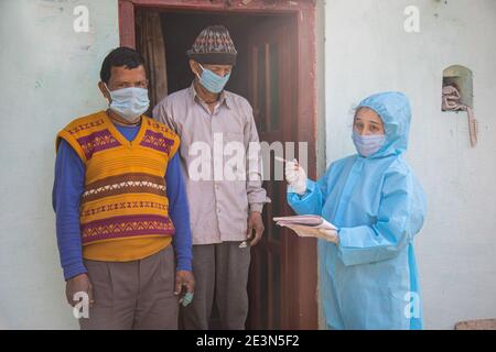 Frauen Krankenschwester Arbeiter in ppe-Kit tun Tür zu Tür Umfragen im indischen Dorf bezüglich Covid-19 Stockfoto