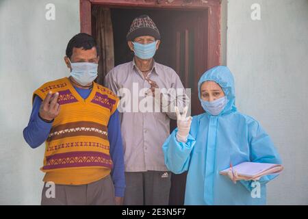 Frauen Krankenschwester Arbeiter in ppe-Kit tun Tür zu Tür Umfragen im indischen Dorf bezüglich Covid-19 Stockfoto