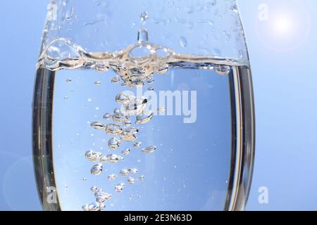 Wasserblase Splash abstrakt in reinem Glas, transparente Weinglas auf Sonnenlicht, natürliche blaue Welle Hintergrund Fotografie Stockfoto