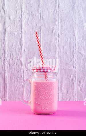 Erdbeershake auf weißem und rosa Hintergrund. Stockfoto