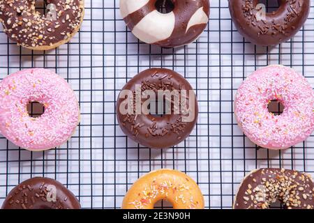 Flache Lay-Komposition aus gemischten Donuts auf weißem Hintergrund. Stockfoto