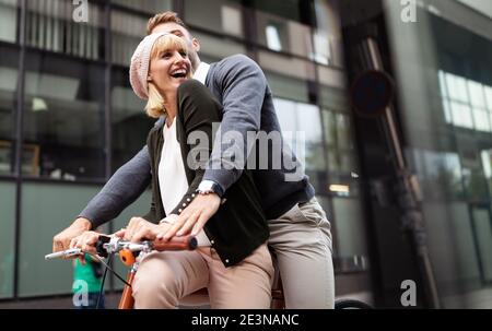 Porträt eines fröhlichen jungen Paares, das mit dem Fahrrad unterwegs ist und gemeinsam im Freien Spaß macht Stockfoto