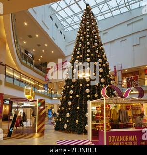 VILNIUS, LITAUEN - 05. DEZEMBER 2020: Weihnachtstanne mit goldenen Kugeln und Geschenken im Panorama-Hypermarkt. Panorama ist das größte Einkaufszentrum Stockfoto