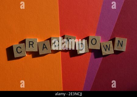 Crackdown, Wort in Holzalphabet Buchstaben isoliert auf bunten Hintergrund Stockfoto