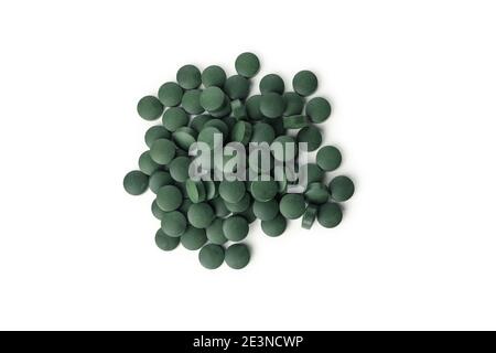 Runder Haufen von Spirulina-Tabletten von oben gesehen auf weißem Hintergrund, ein Spirulina-Nahrungsergänzungsmittel als Ausschnitt für Detox-Designs Stockfoto