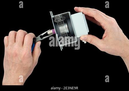 Handwerker reparieren das Mikrowellenmagnetron aus dem elektrischen Mikrowellenofen. Isoliert auf Schwarz Stockfoto