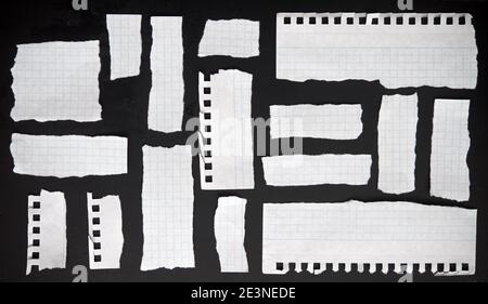 Zerrissene Papiere auf schwarzem Hintergrund Stockfoto