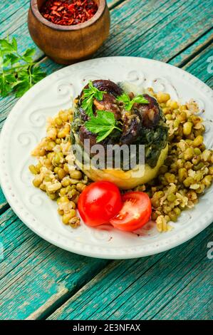 Leckere Polenta mit Pilzen, Maische und Spinat.Corn Polenta mit gerösteten Pilzen Stockfoto