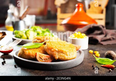 Hühnerschnitzel mit Gemüse auf grauem Teller Stockfoto