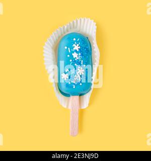 Blaue Minze Eis Eis Eis Eis Eis auf gelbem Hintergrund. Leckeres und erfrischendes Eis auf Stöcken. Minimales Sommerkonzept. Flach liegend. Stockfoto