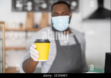 Ein afrikanischer Kellner in einer medizinischen Maske Stockfoto