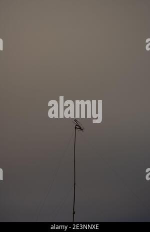 Hoch aufragende alte analoge TV-Antenne in der Nacht mit einem bewölkten Hintergrund. Langzeitbelichtung, Nachtaufnahme. Stockfoto