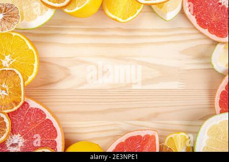 Zitrusrahmen Vorlage auf Holzhintergrund. Frische Zitrusfrüchte. Draufsicht auf geschnittene Zitrusfrüchte. Rahmen aus Zitrusfrüchten Scheiben auf Holzplanken. Stockfoto