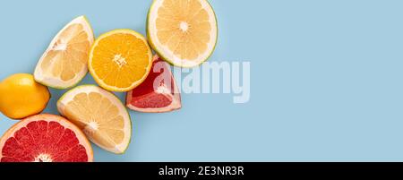 Flatlay Muster aus Zitrusorange, Zitrone, Limette und Grapefruit Scheiben auf blauem Hintergrund. Draufsicht, blauer Hintergrund. Viele verschiedene frische Zitrusfrüchte. Stockfoto