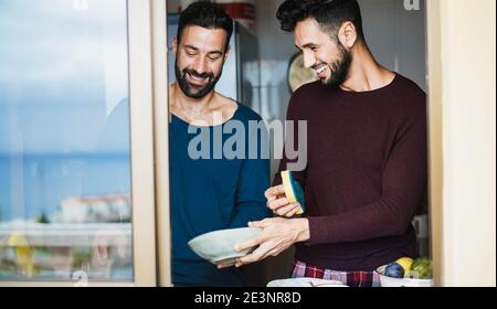 Fensterblick auf Homosexuell paar waschen Geschirr innerhalb Küche - Fokus auf Gesichter Stockfoto