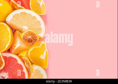 Scheiben von Orange, rosa Grapefruit und Zitronenfrüchten auf rosa Hintergrund. Minimale Zusammensetzung. Rahmen für Obstgerichte. Gesunde Ernährung und Ernährung. Draufsicht flach l Stockfoto
