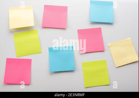 Leere Stickerhinweise auf weißem Hintergrund. Mockup Haftnotizpapier. Leere Blätter für Notizen auf einem weißen Pinnwand Stockfoto