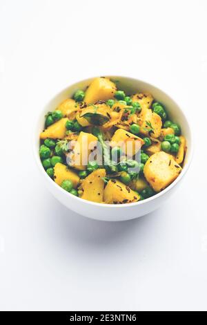 Aloo Mutter oder Matar aalu trocken Sabzi, Indische Kartoffel und grünen Erbsen gebraten zusammen mit Gewürzen und garniert mit Korianderblättern. Serviert mit Roti oder Stockfoto