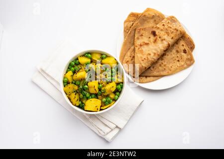 Aloo Mutter oder Matar aalu trocken Sabzi, Indische Kartoffel und grünen Erbsen gebraten zusammen mit Gewürzen und garniert mit Korianderblättern. Serviert mit Roti oder Stockfoto