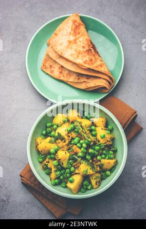 Aloo Mutter oder Matar aalu trocken Sabzi, Indische Kartoffel und grünen Erbsen gebraten zusammen mit Gewürzen und garniert mit Korianderblättern. Serviert mit Roti oder Stockfoto