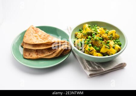 Aloo Mutter oder Matar aalu trocken Sabzi, Indische Kartoffel und grünen Erbsen gebraten zusammen mit Gewürzen und garniert mit Korianderblättern. Serviert mit Roti oder Stockfoto