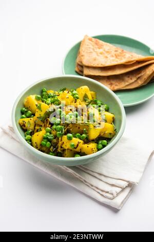 Aloo Mutter oder Matar aalu trocken Sabzi, Indische Kartoffel und grünen Erbsen gebraten zusammen mit Gewürzen und garniert mit Korianderblättern. Serviert mit Roti oder Stockfoto