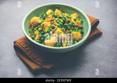 Aloo Mutter oder Matar aalu trocken Sabzi, Indische Kartoffel und grünen Erbsen gebraten zusammen mit Gewürzen und garniert mit Korianderblättern. Serviert mit Roti oder Stockfoto