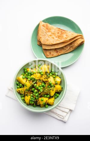 Aloo Mutter oder Matar aalu trocken Sabzi, Indische Kartoffel und grünen Erbsen gebraten zusammen mit Gewürzen und garniert mit Korianderblättern. Serviert mit Roti oder Stockfoto