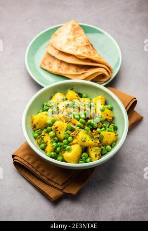 Aloo Mutter oder Matar aalu trocken Sabzi, Indische Kartoffel und grünen Erbsen gebraten zusammen mit Gewürzen und garniert mit Korianderblättern. Serviert mit Roti oder Stockfoto