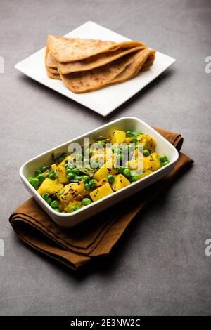 Aloo Mutter oder Matar aalu trocken Sabzi, Indische Kartoffel und grünen Erbsen gebraten zusammen mit Gewürzen und garniert mit Korianderblättern. Serviert mit Roti oder Stockfoto