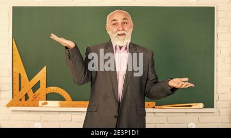 Wer kennt die Antwort. Mathematische grafische Werkzeuge. trigonometrie Unterricht im Klassenzimmer. Holen Sie sich Wissen hier. Senior Mann Lehrer verwenden mathematische Werkzeuge. Bärtigen Dozent Mann erklären Geometrie auf Tafel. Zurück zur Schule. Stockfoto