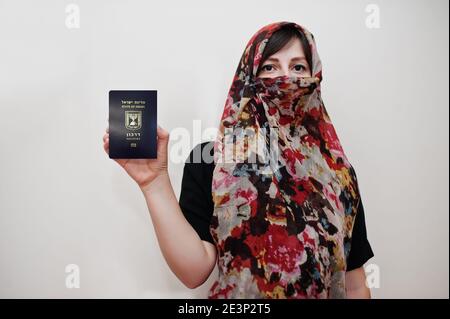 Junge arabische muslimische Frau in Hijab Kleidung halten Staat Israel Pass auf weißen Wand Hintergrund, Studio-Porträt. Stockfoto