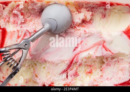 Vanilleeis mit Erdbeer-Variegato und Eislöffel Von oben Stockfoto