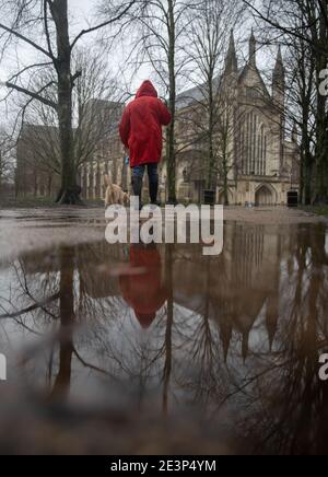 Eine Person geht durch das Gelände der Winchester Cathedral in Winchester, Hampshire, während Storm Christoph weite Überschwemmungen, Stürme und Schnee in Teile Großbritanniens bringen wird. Es wird erwartet, dass es in Großbritannien zu heftigen Regenfällen kommt, wobei das Met Office warnt, dass Häuser und Unternehmen überschwemmt werden und Schäden an einigen Gebäuden verursachen. Bilddatum: Mittwoch, 20. Januar 2021. Stockfoto