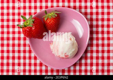 Kugel Erdbeereis von oben mit Variegato und Zwei frische Erdbeeren Stockfoto
