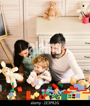 Konzept für Familienspiele. Kid boy, Mutter und Vater spielen Baumeister im Kindergarten zu Hause. Stockfoto