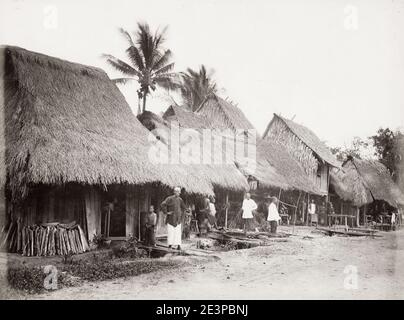 Vintage 19. Jahrhundert Foto: südostasien, wahrscheinlich malaiische Halbinsel, traditionelle Häuser mit Strohdächern, Strohdach und Straßenszene. Stockfoto