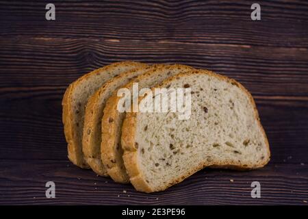 Ein geschnittenes Brot auf einem dunklen Holztisch Stockfoto