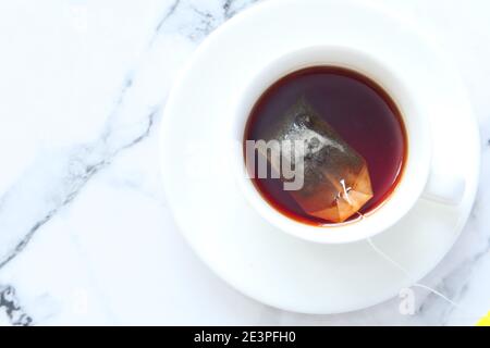 Grüner Tee mit Teebeutel auf Fliesen Hintergrund Stockfoto