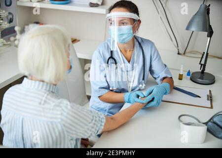 Der medizinische Mitarbeiter führt eine Pulsprüfung durch Stockfoto