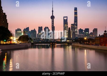 Sonnenaufgang Blick entlang Suzhou Creek von der Zhapu Road Brücke in Richtung Garden Bridge und mit der Pudong Skyline im Hintergrund. Stockfoto